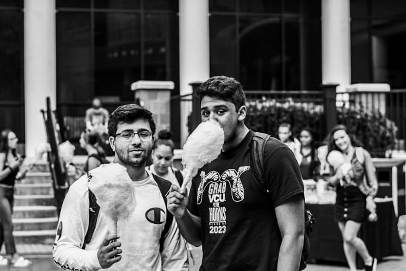 Two students eating cotton candy at an outdoor event at The Commons